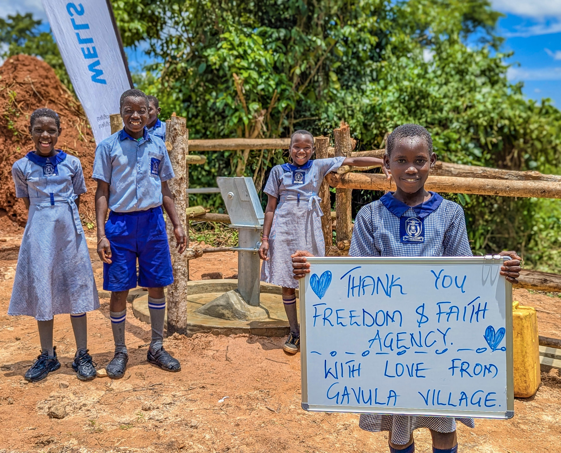 Students from Gayula Village celebrating a clean-water well donated by Freedom & Faith Agency